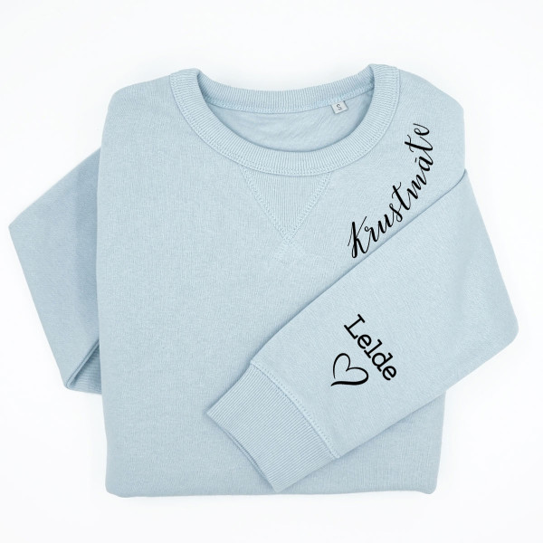 UNISEX pasteļtoņu "Sully" džemperis "Krustmāte" ar bērnu vārdiem uz piedurknes UNISEX pasteļtoņu "Sully" džemperis "Krustmāte" ar bērnu vārdiem uz piedurknes